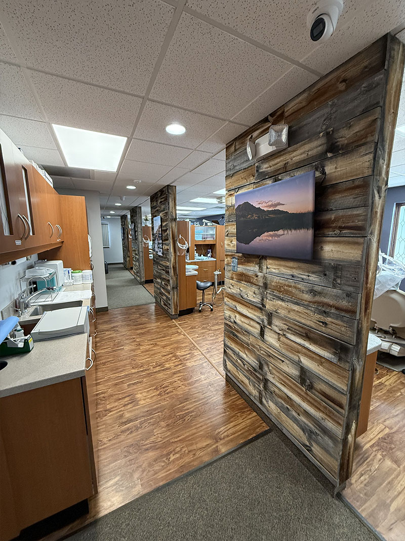 The image depicts an interior space with a rustic wall decoration, a modern television screen, and a clean, well-lit environment.