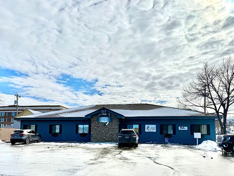 The image shows a two-story building with a blue exterior, featuring a sign that reads  Cold Lake Veterinary Clinic.